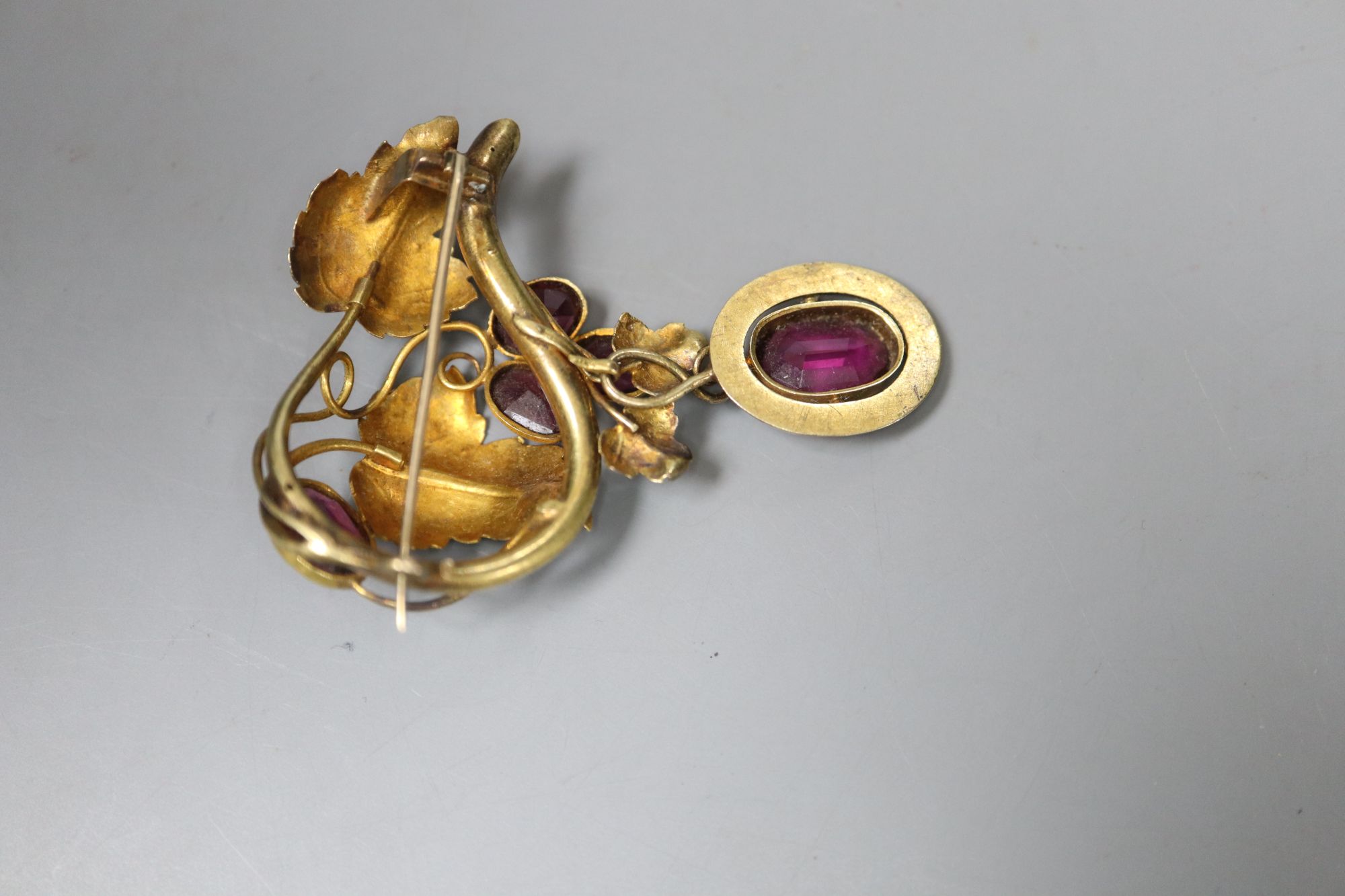 A Victorian garnet and pinchbeck fruiting scroll brooch, 5.75cm